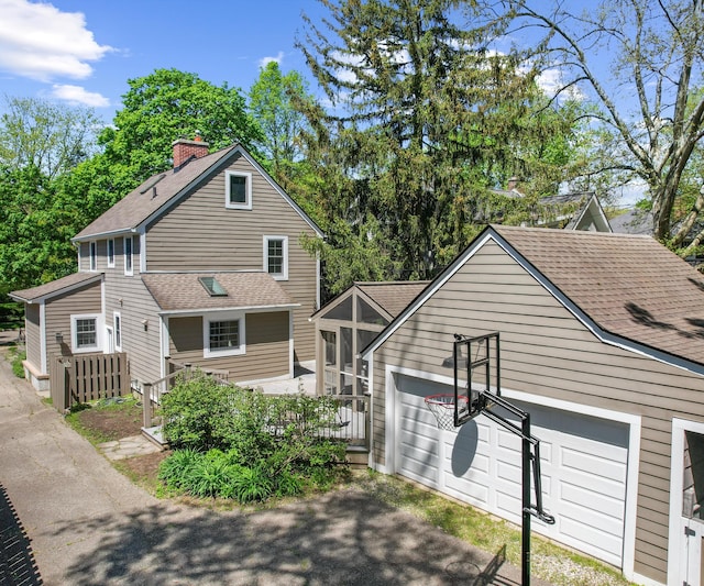 1015 Lincoln Ave, Ann Arbor, MI 48104 - view of front of home with a shingled roof, a sunroom, and a chimney