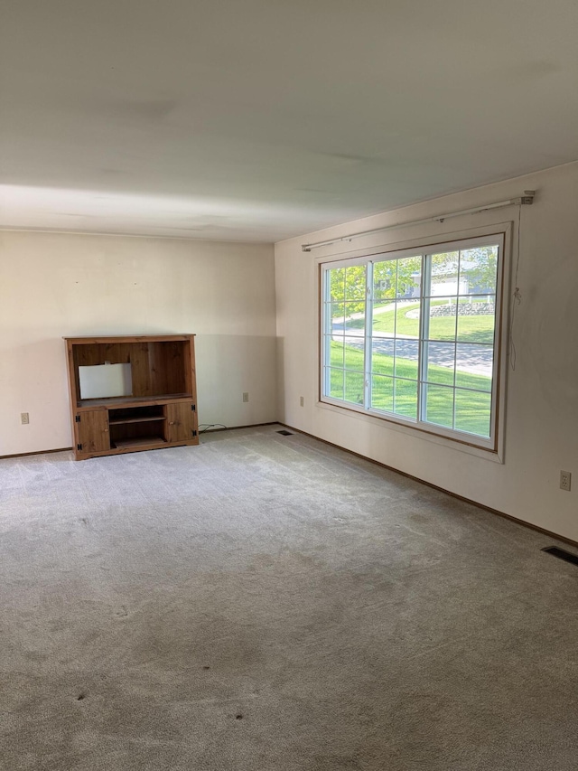 1235 Princeton St, Manistee, MI 49660 - unfurnished living room featuring carpet and baseboards
