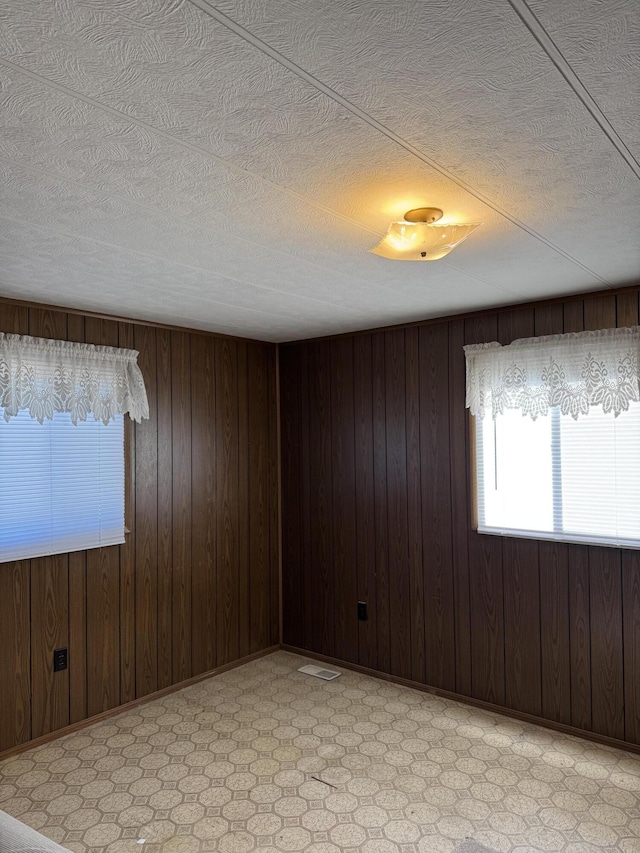 1235 Princeton St, Manistee, MI 49660 - spare room featuring wood walls and a textured ceiling