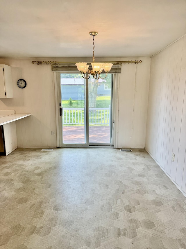 1235 Princeton St, Manistee, MI 49660 - unfurnished dining area featuring a chandelier and wood walls
