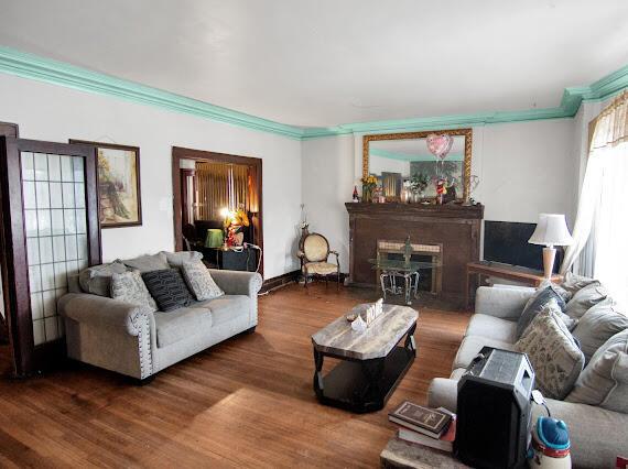 2041 Atkinson St, Detroit, MI 48206 - living area with a fireplace, crown molding, and wood finished floors