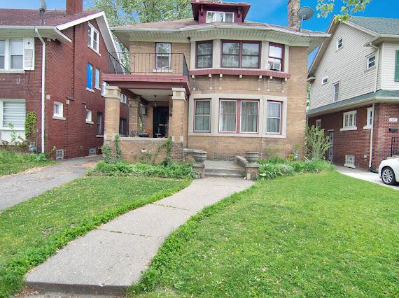 2041 Atkinson St, Detroit, MI 48206 - view of front of home featuring a front lawn, a balcony, brick siding, and a chimney