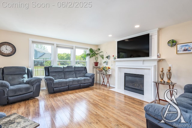 6420 Crestview Dr, Holly, MI 48442 - living area with wood finished floors, a tile fireplace, recessed lighting, and baseboards
