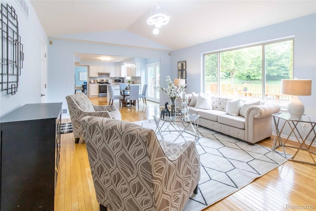 2864 Mystic Dr, Ann Arbor, MI 48103 - living room featuring vaulted ceiling, light wood finished floors, and a chandelier