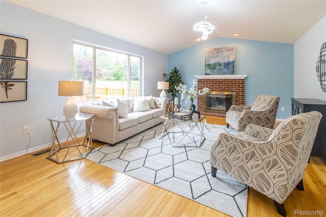 2864 Mystic Dr, Ann Arbor, MI 48103 - living area with wood-type flooring, vaulted ceiling, a brick fireplace, and baseboards