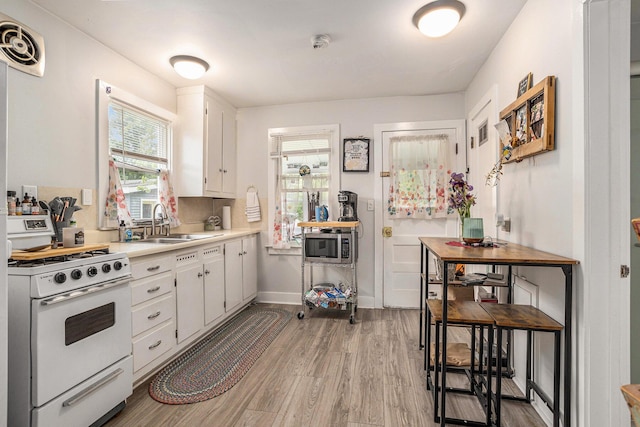 510 Cedar St, Paw Paw, MI 49079 - kitchen with gas range gas stove, a sink, white cabinetry, and light countertops
