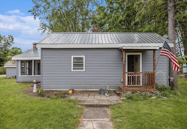 510 Cedar St, Paw Paw, MI 49079 - bungalow-style home featuring metal roof, a front yard, and a chimney