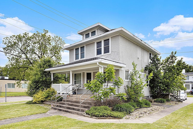 128 S Main St, Lawton, MI 49065 - american foursquare style home with a porch, stucco siding, a front lawn, and stairs