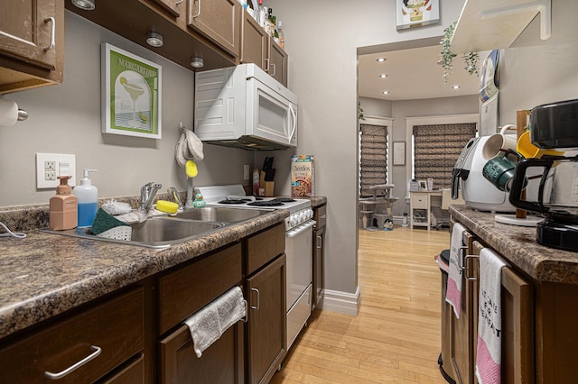 128 S Main St, Lawton, MI 49065 - kitchen with white appliances, light wood finished floors, dark brown cabinetry, dark countertops, and recessed lighting