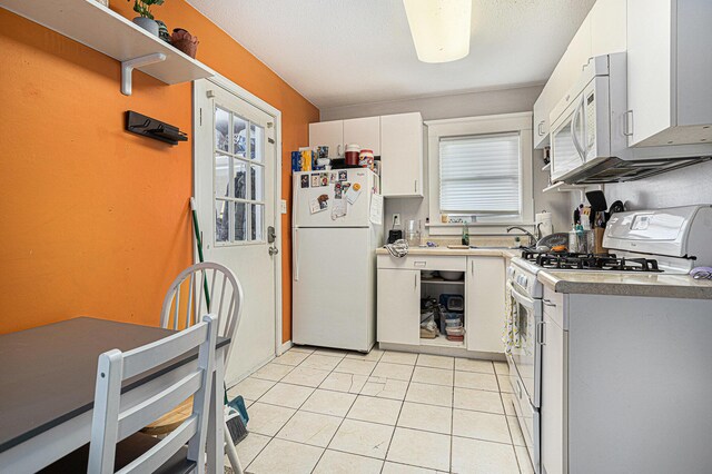 128 S Main St, Lawton, MI 49065 - kitchen featuring white appliances, white cabinets, light tile patterned floors, and light countertops