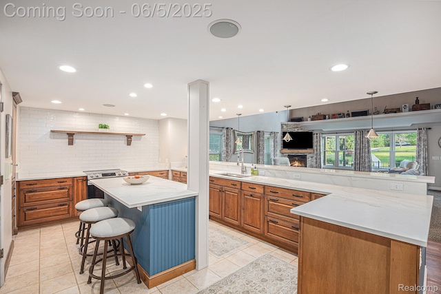 6080 Waldon Rd, Clarkston, MI 48346 - kitchen with a spacious island, a sink, brown cabinetry, electric stove, and backsplash