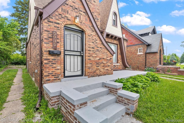 5935 Devonshire Rd, Dearborn, MI 48224 - doorway to property featuring brick siding and roof with shingles
