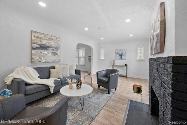 5935 Devonshire Rd, Dearborn, MI 48224 - living area featuring arched walkways, recessed lighting, a textured ceiling, plenty of natural light, and light wood-style floors