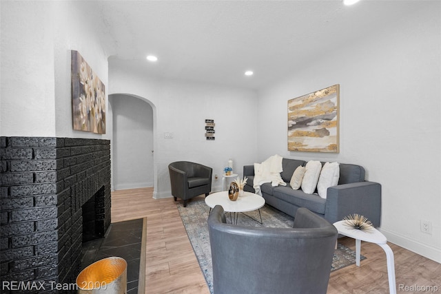 5935 Devonshire Rd, Dearborn, MI 48224 - living area featuring arched walkways, a fireplace, recessed lighting, light wood-type flooring, and baseboards