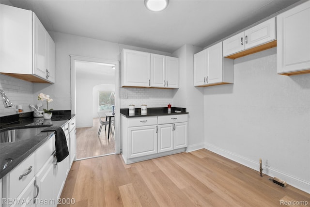 5935 Devonshire Rd, Dearborn, MI 48224 - kitchen with light wood-style flooring, backsplash, white cabinets, and baseboards