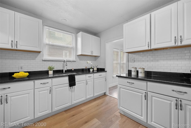 5935 Devonshire Rd, Dearborn, MI 48224 - kitchen featuring a sink, white cabinetry, tasteful backsplash, and light wood finished floors