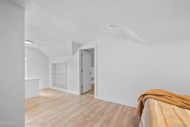 5935 Devonshire Rd, Dearborn, MI 48224 - additional living space featuring built in features, lofted ceiling, baseboards, wood finished floors, and a textured ceiling