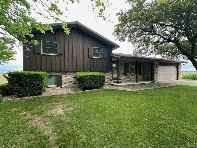 19379 Lincoln Rd, New Lothrop, MI 48460 - view of front of property featuring brick siding, a front lawn, an attached garage, driveway, and board and batten siding
