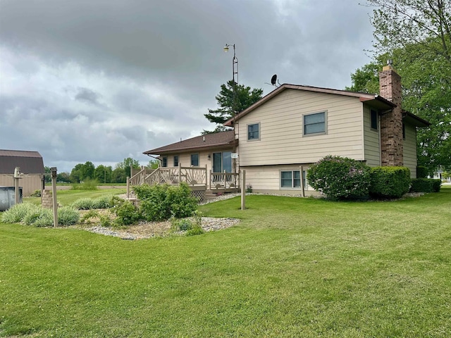19379 Lincoln Rd, New Lothrop, MI 48460 - back of property featuring a deck, a chimney, and a lawn