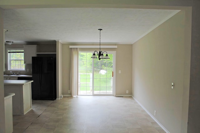 11200 Willard Rd, Burt, MI 48417 - unfurnished dining area with a chandelier, ornamental molding, baseboards, and a sink