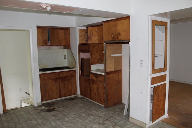 1609 Ohio Ave, Flint, MI 48506 - kitchen featuring tile patterned floors, brown cabinets, and tasteful backsplash