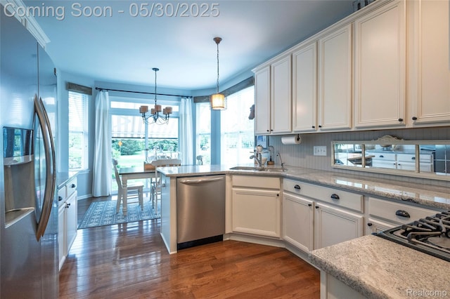 26727 Wilton Ct, New Hudson, MI 48165 - kitchen with appliances with stainless steel finishes, a sink, healthy amount of natural light, and a chandelier