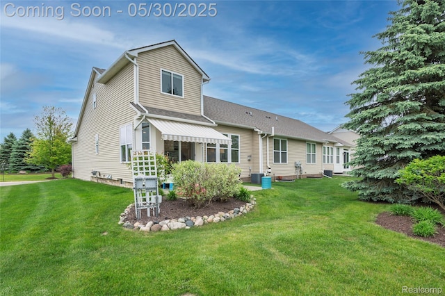 26727 Wilton Ct, New Hudson, MI 48165 - back of property featuring a lawn and a shingled roof