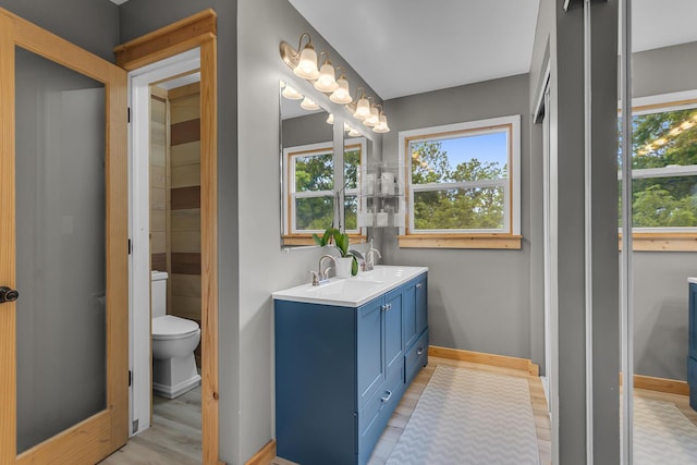 9410 US Highway 12, Brooklyn, MI 49230 - bathroom with double vanity, toilet, wood finished floors, and baseboards