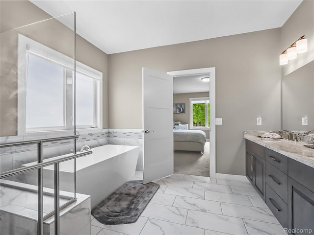 50011 Anita Way N, Macomb, MI 48044 - full bath featuring marble finish flooring, connected bathroom, double vanity, a freestanding tub, and baseboards