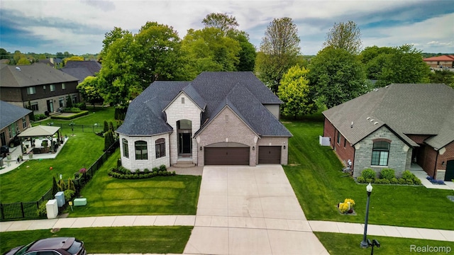 50011 Anita Way N, Macomb, MI 48044 - french country home with stone siding, a garage, concrete driveway, brick siding, and a shingled roof