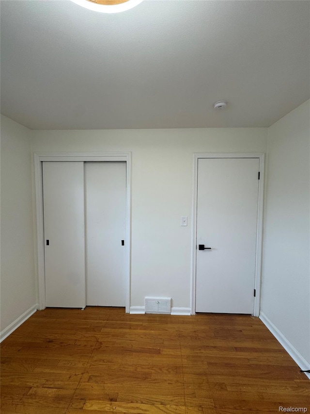 8511 Allen Rd, Allen Park, MI 48101 - unfurnished bedroom with wood finished floors, a closet, and baseboards