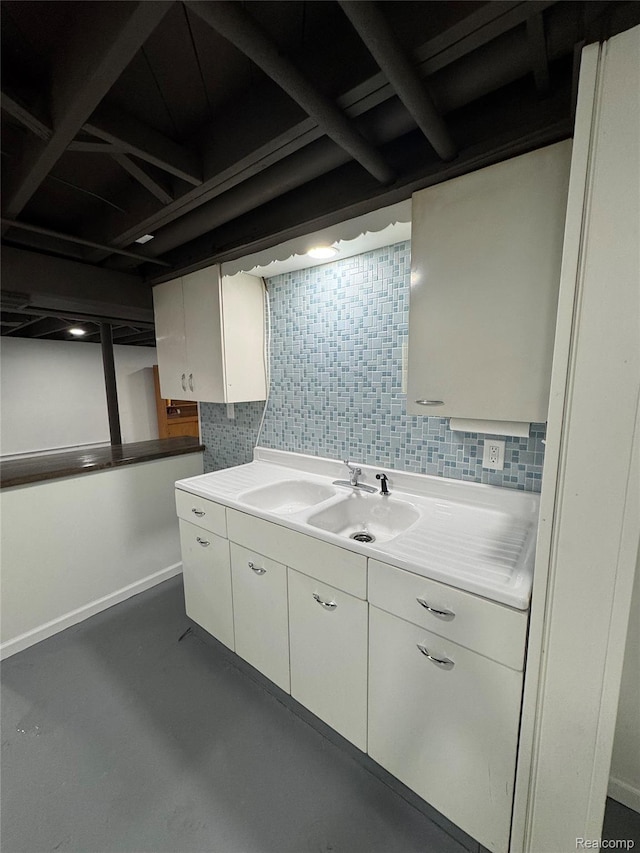 8511 Allen Rd, Allen Park, MI 48101 - kitchen featuring white cabinets, concrete flooring, light countertops, a sink, and baseboards