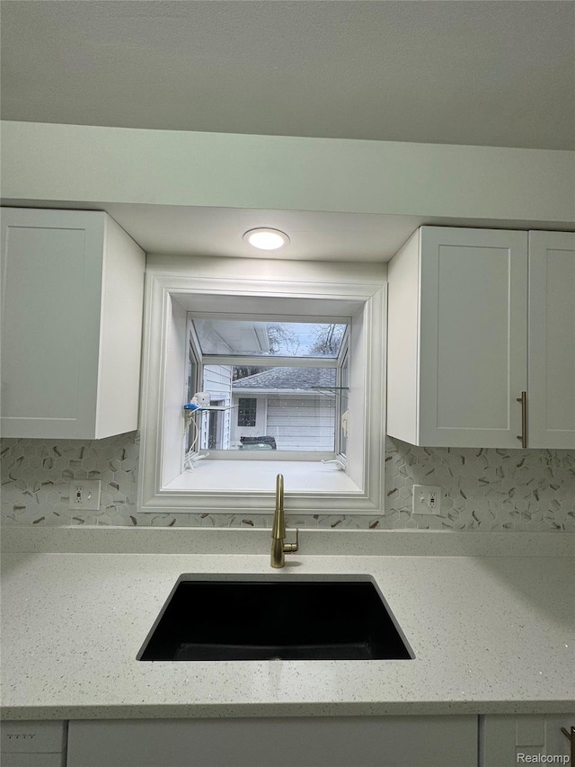 8511 Allen Rd, Allen Park, MI 48101 - kitchen view of a sink, white cabinets, and light stone counters