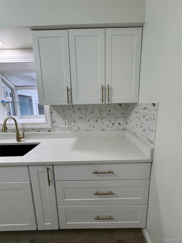 8511 Allen Rd, Allen Park, MI 48101 - kitchen view of a sink, white cabinetry, light stone countertops, backsplash, and dark wood-style flooring