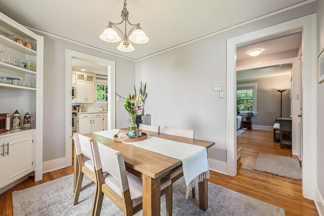 1512 Brooklyn Ave, Ann Arbor, MI 48104 - dining area with a chandelier, light wood finished floors, baseboards, and ornamental molding