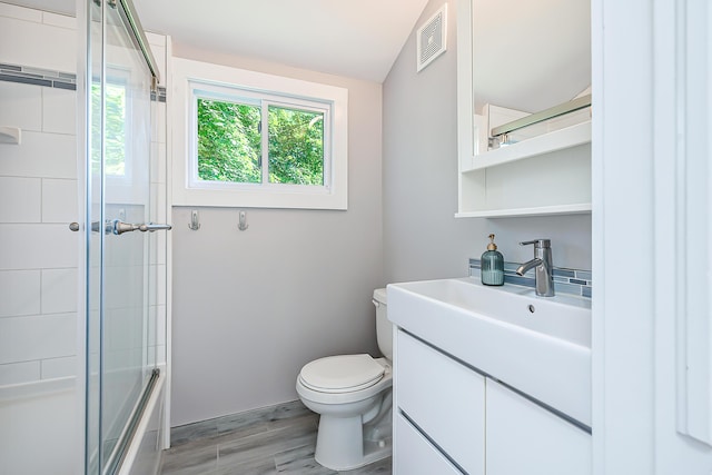 1512 Brooklyn Ave, Ann Arbor, MI 48104 - full bath with toilet, wood finished floors, vanity, and combined bath / shower with glass door