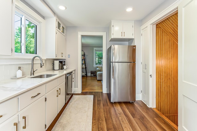 1512 Brooklyn Ave, Ann Arbor, MI 48104 - kitchen featuring appliances with stainless steel finishes, a sink, dark wood-style floors, white cabinetry, and decorative backsplash