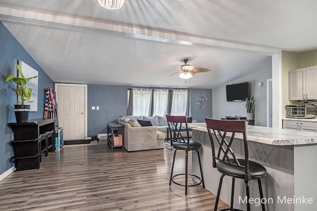 7813 River St, Belding, MI 48809 - kitchen with a breakfast bar area, dark wood-type flooring, light countertops, white cabinets, and ceiling fan
