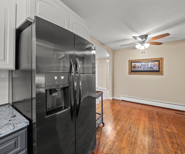 4841 Pear Way, Farwell, MI 48622 - kitchen with refrigerator with ice dispenser, a ceiling fan, wood finished floors, white cabinetry, and baseboard heating