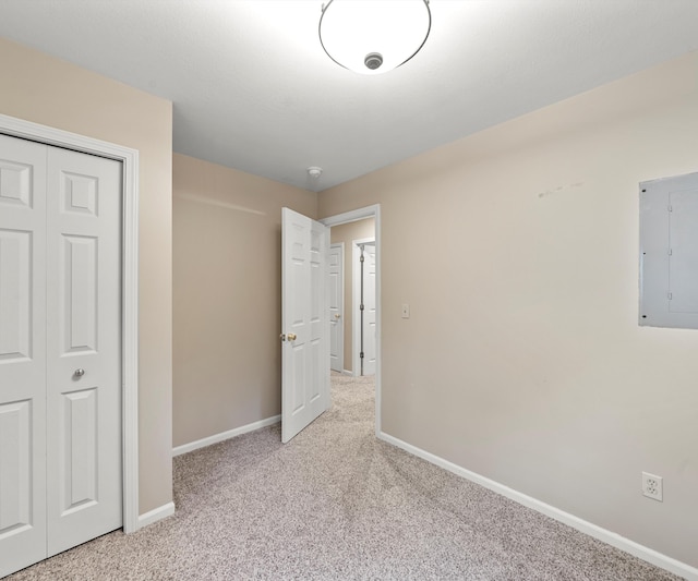 4841 Pear Way, Farwell, MI 48622 - unfurnished bedroom with electric panel, light colored carpet, baseboards, and a closet