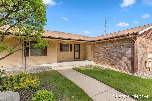 2870 S Wentward Ct, Hudsonville, MI 49426 - doorway to property with brick siding, a porch, roof with shingles, and a yard