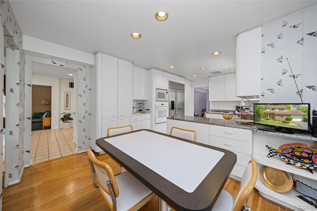 29832 High Valley Ct, Farmington Hills, MI 48331 - kitchen featuring built in appliances, light wood-style flooring, white cabinets, recessed lighting, and a peninsula