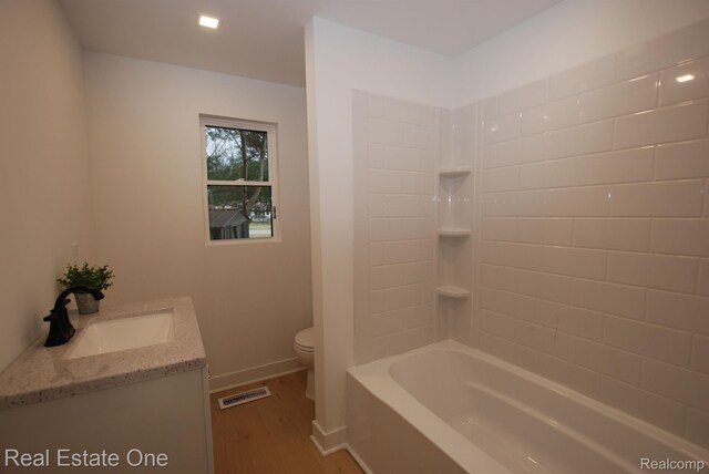 12357 Raymond Dr, Clio, MI 48420 - full bathroom with toilet, wood finished floors, vanity, baseboards, and tub / shower combination