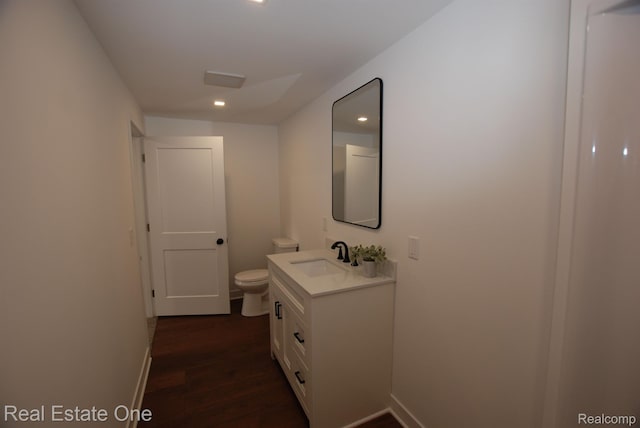 12357 Raymond Dr, Clio, MI 48420 - bathroom featuring vanity, toilet, wood finished floors, baseboards, and recessed lighting
