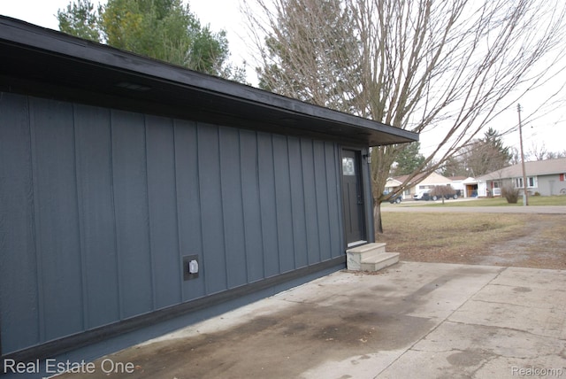 12357 Raymond Dr, Clio, MI 48420 - view of side of home featuring a patio area and board and batten siding