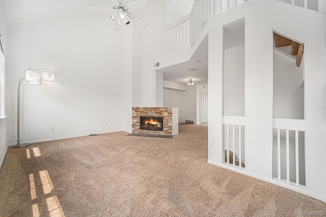 170 Allenhurst Ave, Royal Oak, MI 48067 - unfurnished living room with carpet flooring, a towering ceiling, a ceiling fan, a stone fireplace, and baseboards