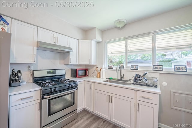 7265 Hillside Dr, Dearborn, MI 48127 - kitchen with stainless steel range with gas cooktop, under cabinet range hood, a sink, white cabinets, and light countertops