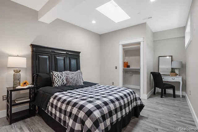 344 Main St Unit 300, Milford, MI 48381 - bedroom featuring a skylight, light wood-style floors, baseboards, a walk in closet, and recessed lighting