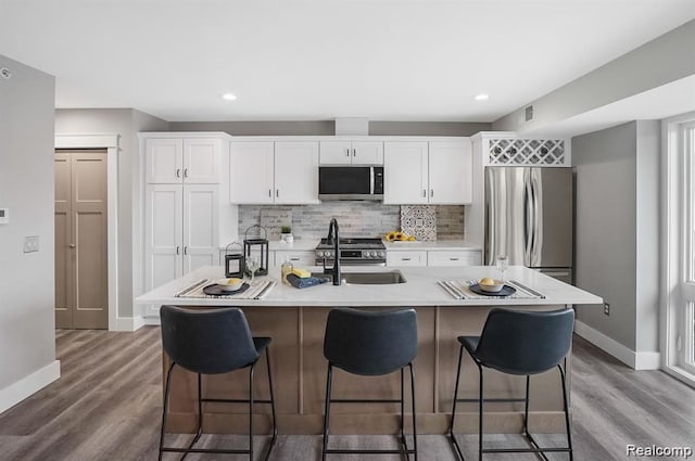 344 Main St Unit 300, Milford, MI 48381 - kitchen with appliances with stainless steel finishes, a sink, baseboards, backsplash, and wood finished floors