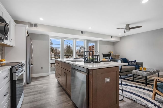 344 Main St Unit 300, Milford, MI 48381 - kitchen with stainless steel appliances, a breakfast bar, a sink, a kitchen island with sink, and recessed lighting